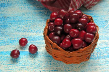 Olgun Kiraz sepeti yaz yeşillik güneş ışığı altında karşı kırsal üzerinde eski ahşap tablo 