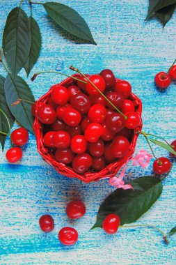 Eski ahşap masa üzerinde sepette Olgun Kiraz 