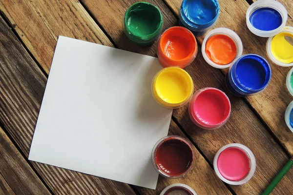 Tintas de guache. jogo de nove pinturas de guache de cores em jarros na mesa de madeira. Foco em vermelho — Fotografia de Stock