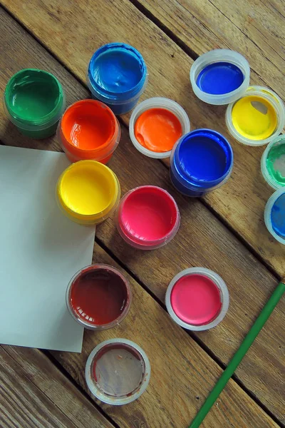 Juego de nueve colores gouache pinturas en frascos sobre mesa de madera. Enfoque en rojo — Foto de Stock