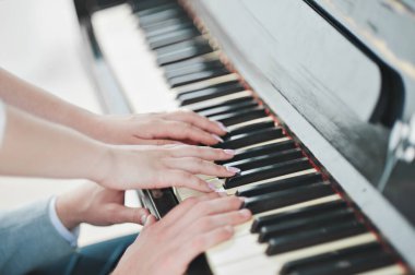 Gelin ve damat piyano çalıyor. kollar.