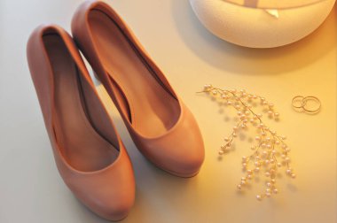 Ayakkabılar ve alyanslar masada.