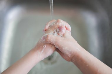 Coronavirus 'un önlenmesi, grip hastalığı. Çocuk, çocuk antibakteriyel sabunla, sıcak suyla ovalayarak ve parmaklarını lavaboya sürterek ellerini yıkar. El yıkama ve hijyen. Covid-19. Koronavirüsü yaymayı bırakmak için..