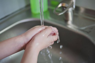 Coronavirus 'un önlenmesi, grip hastalığı. Çocuk, çocuk antibakteriyel sabunla, sıcak suyla ovalayarak ve parmaklarını lavaboya sürterek ellerini yıkar. El yıkama ve hijyen. Covid-19. Koronavirüsü yaymayı bırakmak için..