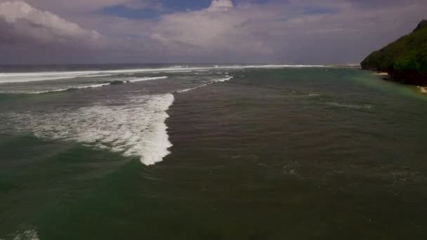 Luchtfoto drone 4k beelden van de oceaan golven breken voordat de oever. Bali, Indonesië — Stockvideo