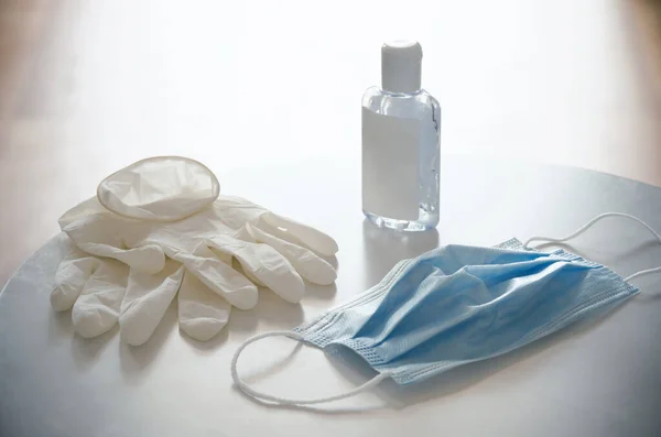 Protective devices to go out your house safely during the viral emergency, pandemic caused by Coronavirus (COVID-19): disposable surgical mask, latex gloves and hand sanitizer gel.