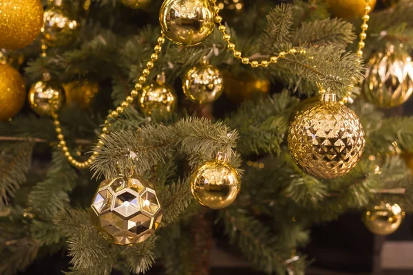 Brinquedos de Natal cor de ouro no verde a árvore de Natal — Fotografia de Stock