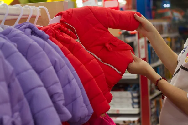 Alışveriş genç kadın, Bebek için stand ceket dükkanda ile ilgilenen el ile