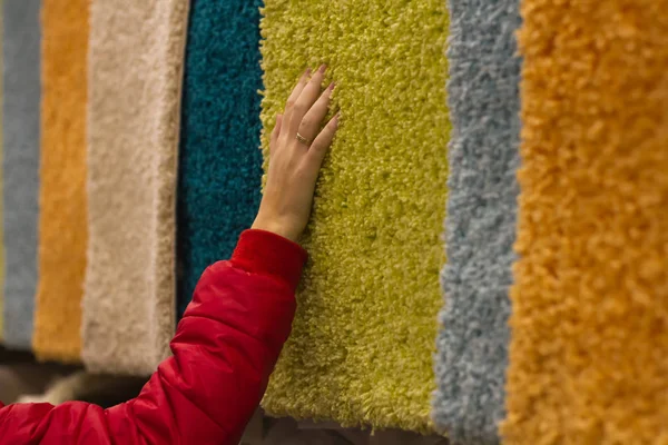 Kadın alışveriş harcıyor ve peluş Halı deposunda elle seçer