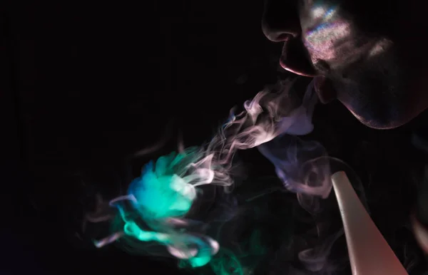 Produit de la fumée sous forme de bouche Medusas dans les rayons colorés de la lumière — Photo