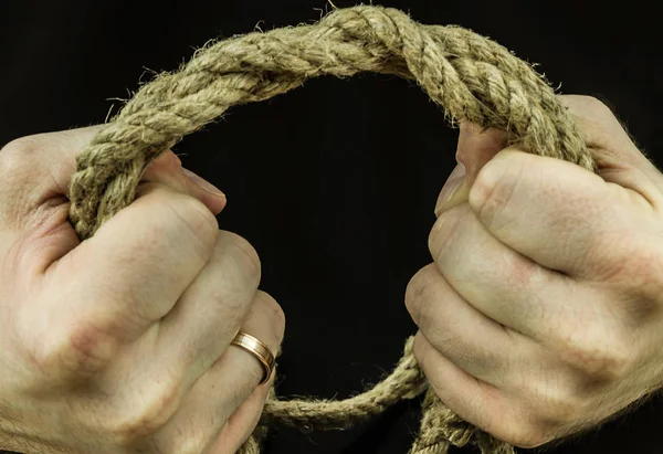 Braided coconut rope in the hands of men in tension squeezing