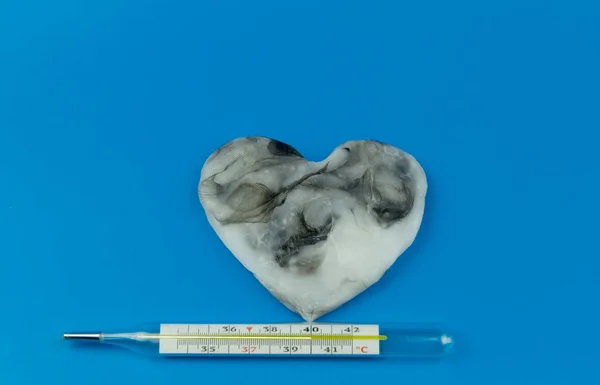 Серце чорне з білим кольором і термометром для вимірювання температури людського тіла — стокове фото