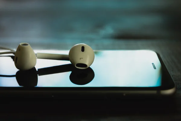 Close up headphone stack on phone in black color tone, new headp — Stock Photo, Image