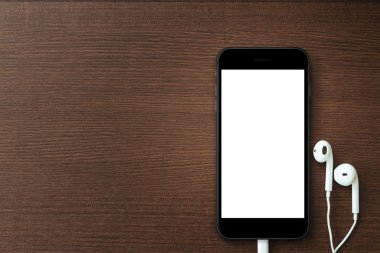 telefonu boş ekran ve ahşap masa, mockup yeni telefon üzerinde kulaklık