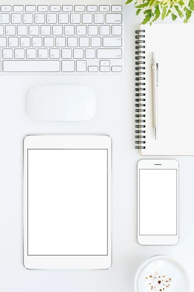 Phone and tablet blank screen on white table format vertical top — Stockfoto