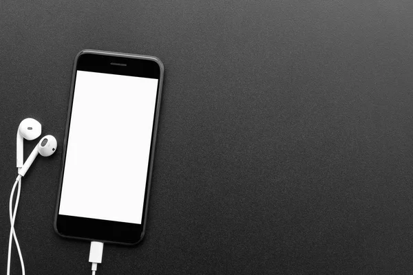 Черный телефон и наушники на столе вид сверху с копирайтом — стоковое фото