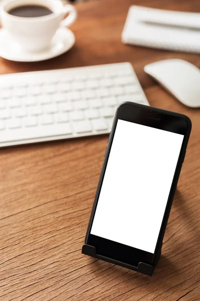 Teléfono móvil en la mesa que muestra la pantalla en blanco — Foto de Stock