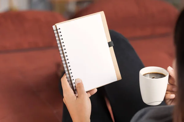 Selective focus on woman reading notebook and holding coffee cup — Stock Photo, Image