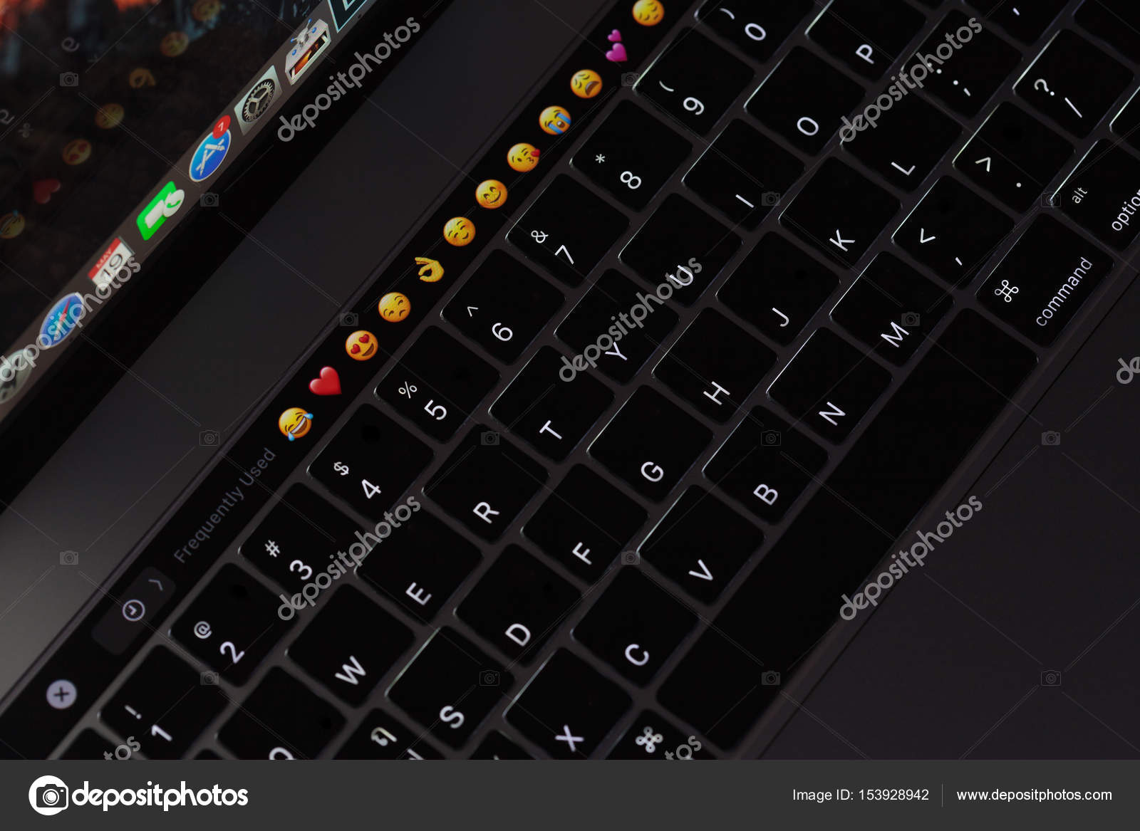 Closeup new macbook pro 2016 keyboard showing illuminated and emoji on touch bar Stock