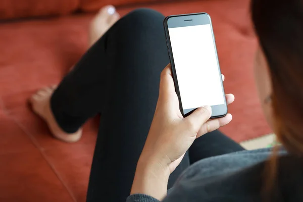 Primer plano de las mujeres utilizan la pantalla blanca móvil del teléfono inteligente en la decoración del sofá — Foto de Stock