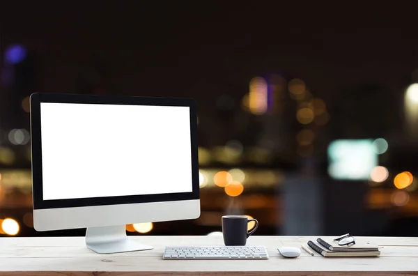 desktop computer on work table and city night background