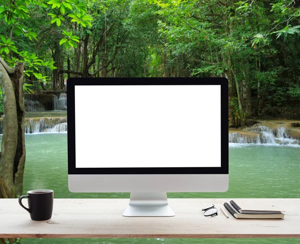 Computador desktop moldura branca na mesa de trabalho e natureza cachoeira — Fotografia de Stock