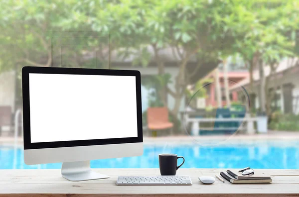 Computador desktop na mesa de trabalho e ver através do hotel resort de volta — Fotografia de Stock