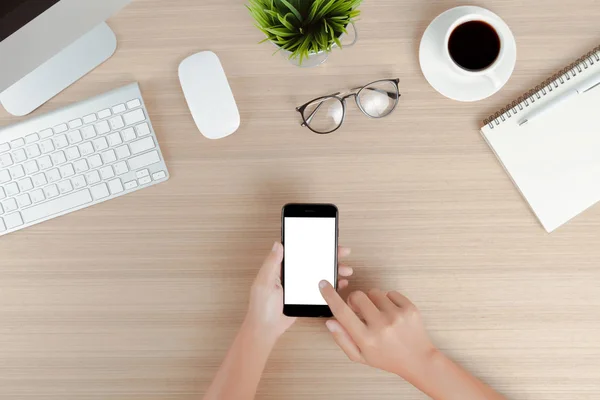 Uso de la mano teléfono móvil pantalla blanca en la mesa de trabajo vista superior —  Fotos de Stock