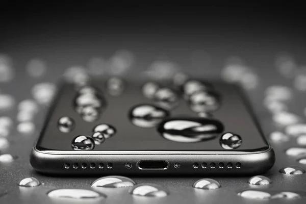 Крупним планом телефон повинен бути водонепроникним пострілом на чорному тлі — стокове фото