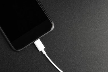 siyah arka plan üstten görünüm üzerindeki USB bağlantı noktasına bağlanan telefon