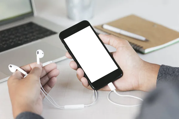 Close-up hand holding phone on work desk — Stock Photo, Image