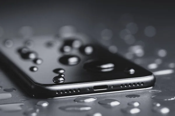 Крупним планом телефон буде водонепроникним пострілом на чорному тлі — стокове фото