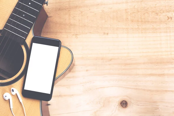 Telefone celular mostrando tela na guitarra conceito de música vista superior — Fotografia de Stock