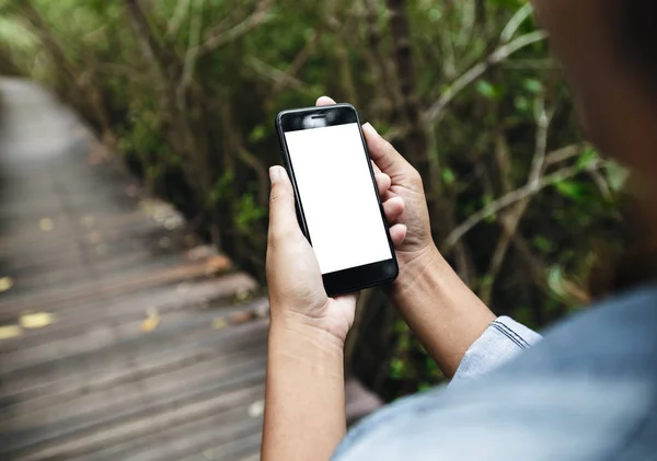 Menina segurar telefone inteligente andando na estrada — Fotografia de Stock