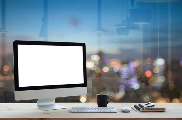 Desktop-Computer am Arbeitstisch und nächtlicher Hintergrund in der Stadt — Stockfoto