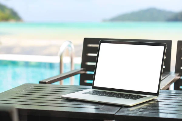 Laptop computador mostrando tela em branco na mesa beleza praia backg — Fotografia de Stock