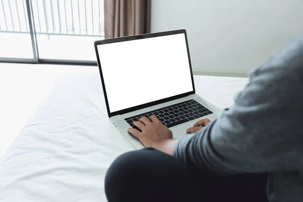 Mujer tecleando teclado portátil que muestra la pantalla blanca en la cama dentro — Foto de Stock