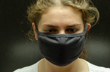 Tıbbi maskeli bir kız. Coronovirus. Tüm dünyanın salgını..