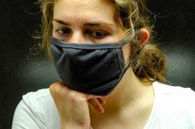 Tıbbi maskeli bir kız. Coronovirus. Tüm dünyanın salgını..