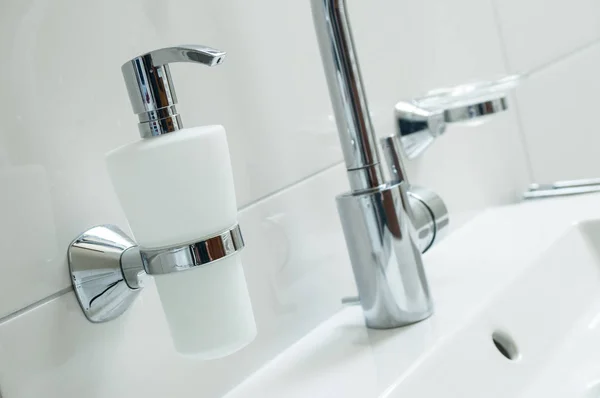 Sanitaire avec robinet en chrome et salle de bain blanche — Photo
