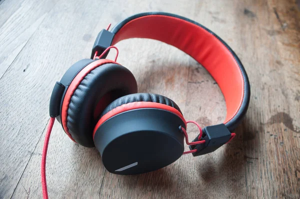 Red and black headphones on wooden table background — Stock Photo, Image