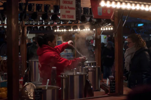 Mujer dando vino caliente en el mercado de Navidad por la noche —  Fotos de Stock