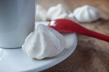  Meringues ve ahşap masa arka plan üzerinde kahve