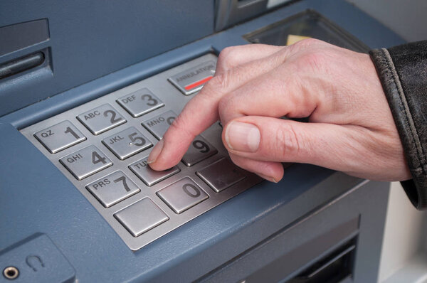 hand of man at the automated machine of bank