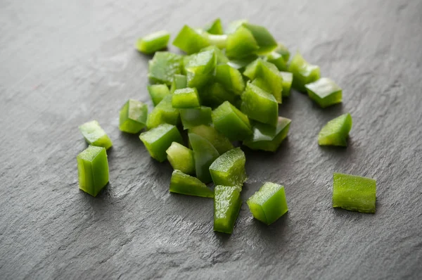 Cubos de pimientos verdes en el fondo de pizarra —  Fotos de Stock