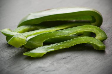  Kara tahta zemin üzerine yeşil biber dilimlenmiş