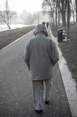 hood montlu bir yolda yürüyen adam