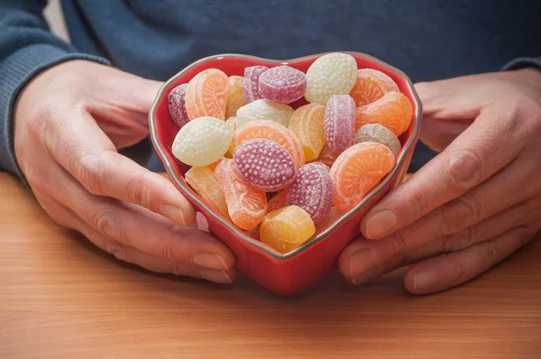 Чоловічі руки з традиційними цукерками у формі серця — стокове фото