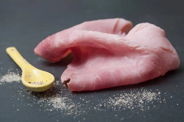 Sliced ham on chalkboard background — Stock Photo, Image