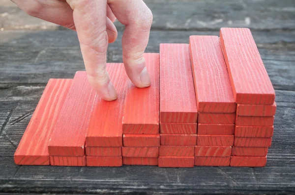 Escada de madeira vermelha com peça de tijolo de madeira de jogo de construção em fundo de madeira — Fotografia de Stock